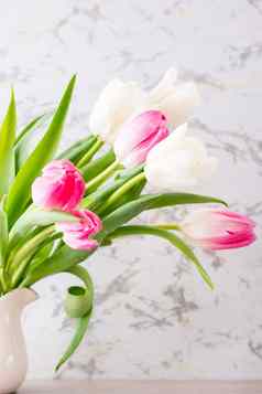 花束白色粉红色的郁金香绿色叶子站壶表格垂直视图精致的明信片