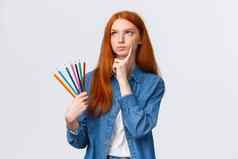 深思熟虑的集中严肃的表情确定红色头发的人女学生少年画有趣的持有彩色的铅笔思考思考的想法
