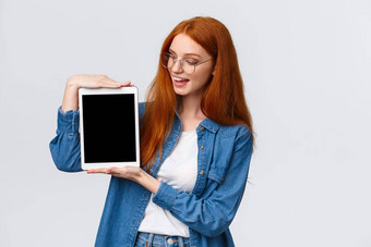 技术人概念有吸引力的有创意的年轻的红色头发的人女孩创建设计<strong>项目</strong>大学持有数字平板电脑<strong>介绍</strong>设备屏幕白色背景