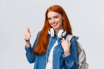 女孩发现优秀的兼职工作大学类有吸引力的红色头发的人女人背包耳机脖子显示翘拇指微笑批准推荐