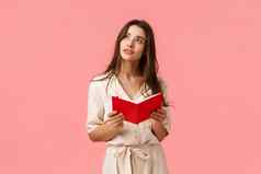 深思熟虑的启发有创意的女学生灵感梦幻想知道持有红色的笔记本学习准备类站粉红色的背景