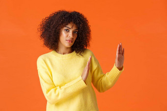 严肃的表情自信的确定非裔美国人女人相机使停止拒绝手势一边下降提供感觉不情愿的站橙色背景