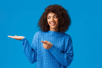有魅力的可爱的微笑非裔美国人女帮助家庭安排表格假期收集指出手指左展示手站蓝色的背景快乐的