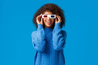 让看寒冷快乐有魅力的非裔美国人女享受首映太棒了电影把眼镜电影微笑屏幕着迷站蓝色的背景