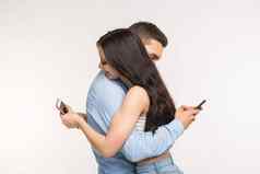 智能手机上瘾概念年轻的夫妇拥抱打字手机