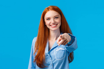 快乐的自信红色头发的人女孩使保证选择指出手指相机微笑决定挑选变<strong>体会</strong>说话的人站睡衣蓝色的背景