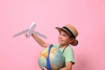 可爱的孩子男孩戏剧纸飞机模拟飞行地球地球概念旅行旅游地理位置航空粉红色的背景复制空间