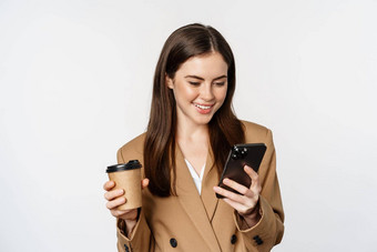 肖像女售货员企业女人喝外卖咖啡阅读智能手机移动电话白色背景