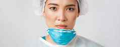 科维德冠状病毒疾病医疗保健工人概念特写镜头疲惫严肃的表情亚洲女医生起飞个人保护设备皮肤损害呼吸器