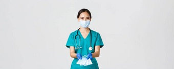 科维德冠状病毒疾病医疗保健工人概念友好的微笑亚洲医生女医生实习医生风云橡胶手套将医疗面具病人白色背景