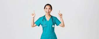 科维德医疗保健工人流感大流行概念逗乐快乐的亚洲女护士医生外科医生实习医生风云指出手指满意脸站白色背景