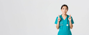 科维德医疗保健工人流感大流行概念充满希望的紧张亚洲女实习生实习医生风云等待新闻医生交叉手指咬唇上左角落里祈祷