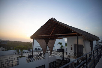 美丽的视图棕榈屋顶前酒店建筑日落背景