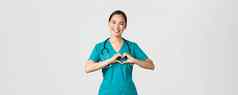 科维德医疗保健工人流感大流行概念可爱的有爱心的亚洲医生女护士实习医生风云显示心手势微笑采取护理病人爱白色背景