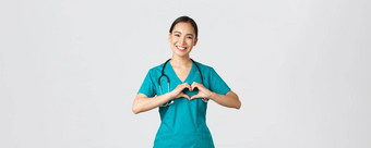科维德医疗保健工人流感大流行概念可爱的有爱心的亚洲医生女护士实习医生风云显示心手势微笑采取护理病人爱白色背景