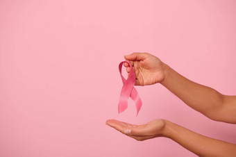 女人手持有<strong>粉</strong>红色的丝带象征世界乳房癌症意识一天10月女人的健康医疗概念10月<strong>粉</strong>红色的一天世界癌症一天国家癌症幸存者一天