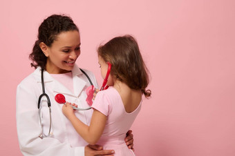漂亮的女孩粉红色的衣服听诊器听胸部肺呼吸医生粉红色的丝带胸部概念教育程序支持乳房癌症病人复制空间