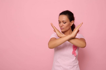 自信肖像美丽的宁静非洲美国女人穿粉红色的t恤癌症意识丝带手势停止手相机摆姿势粉红色的背景复制空间