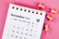 12月桌子上日历木销粉红色的背景