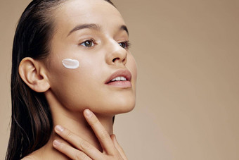女人应用舒缓的脸面具化妆品青年皮肤护理概念