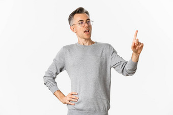 图像自信中年商人灰色毛衣眼镜指出手指使演讲给任务员工站白色背景