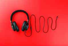 无线黑色的耳机红色的背景声音频率使耳机线入耳式耳机玩游戏听音乐跟踪