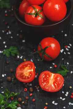 多汁的红色的樱桃西红柿黑色的背景香料粗盐绿色切片甜蜜的成熟的西红柿沙拉成分烹饪