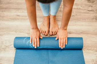 女人手滚瑜伽席健身房地板上瑜伽健身培训房间首页锻炼女人关闭手滚动泡沫瑜伽健身房席女人光着脚首页锻炼运动型健康的生活方式概念