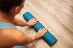 女人手滚瑜伽席健身房地板上瑜伽健身培训房间首页锻炼女人关闭手滚动泡沫瑜伽健身房席女人光着脚首页锻炼运动型健康的生活方式概念