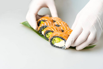 烹饪手使日本寿司卷日本老板工作准备美味的寿司卷鳗鱼鳄梨开胃的日本食物