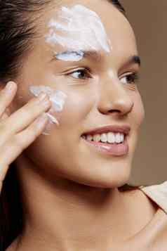 年轻的女人脸面具奶油清洁皮肤面部擦洗特写镜头