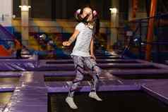 孩子跳蹦床在室内操场上活跃的蹒跚学步的女孩有趣的体育运动中心