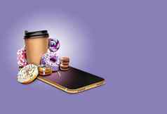 智能手机紫罗兰色的背景甜甜圈糖果拐杖咖啡饼干巧克力马卡龙拼贴画复制空间特写镜头