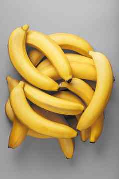 群新鲜的黄色的香蕉灰色的背景时尚颜色