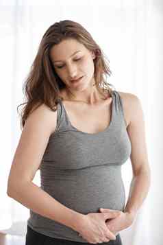 经历end-of-pregnancy抽筋裁剪拍摄年轻的怀孕了女人持有胃疼痛站首页