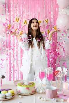 美丽的女人庆祝生日聚会，派对扔粉红色的五彩纸屑