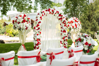 婚礼仪式在户外婚礼拱装饰红色的花