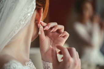 婚礼耳环女人的手需要耳环新娘费用早....新娘白色衣服穿耳环