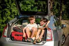 可爱的男孩坐着车树干假期父母孩子们向前路旅行旅行夏天打破学校家庭旅行车