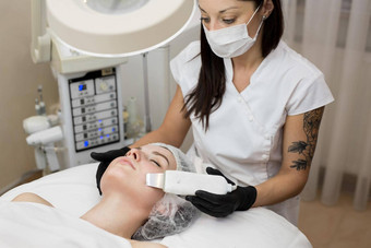皮肤护理特写镜头美丽的女人接收超声波空化面部剥超声波皮肤清洗过程美治疗美容美水疗中心沙龙