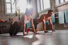 肌肉发达的男人。健身房运动女人执行体育练习
