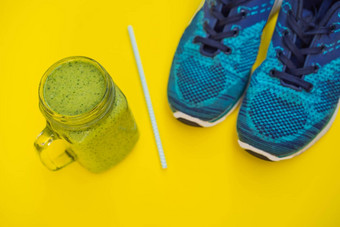 体育绿松石蓝色的阴影黄色的背景菠菜冰沙瑜伽席体育运动鞋子运动服装瓶水概念健康的生活方式体育运动饮食体育运动设备复制空间