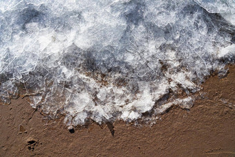 冰海滩边境冬天夏天冰沙子冷温暖的对比过渡