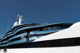底视图甲板巨大的游艇蓝色的颜色阳光明媚的一天光滑的董事会电动机船太阳反射光滑的董事会蓝色的天空背景