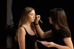 化妆艺术家适用于眼睛影子美丽的女人脸手维萨吉斯特绘画化妆品年轻的美模型女孩使过程