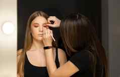 化妆艺术家适用于眼睛影子美丽的女人脸手维萨吉斯特绘画化妆品年轻的美模型女孩使过程