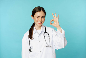 肖像满意微笑医疗工人女人医生显示问题手势优秀的标志站很高兴毙瑁背景