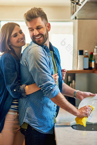 更大的壮阳药男人。菜肖像年轻的快乐女人拥抱丈夫洗菜首页