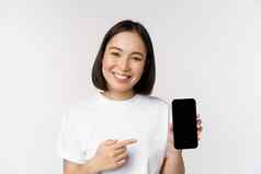 微笑亚洲女人指出手指智能手机屏幕显示应用程序接口移动电话网站站白色背景