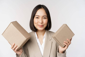 图像女售货员亚洲女商人持有盒子公司品牌产品微笑相机站白色背景